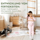 Kind sitzt auf Holz-Strickleiter im Montessori-inspirierten Kinderzimmer mit Spielzeug, verysuperb